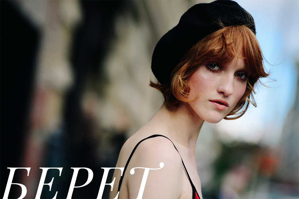 Model with red hair wearing beret and top